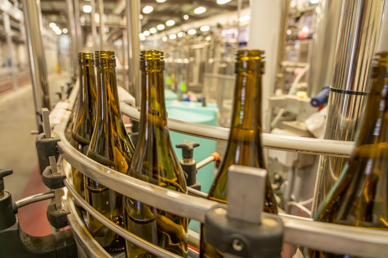 Close-up view of glass bottles on an industrial production line in a manufacturing facility.